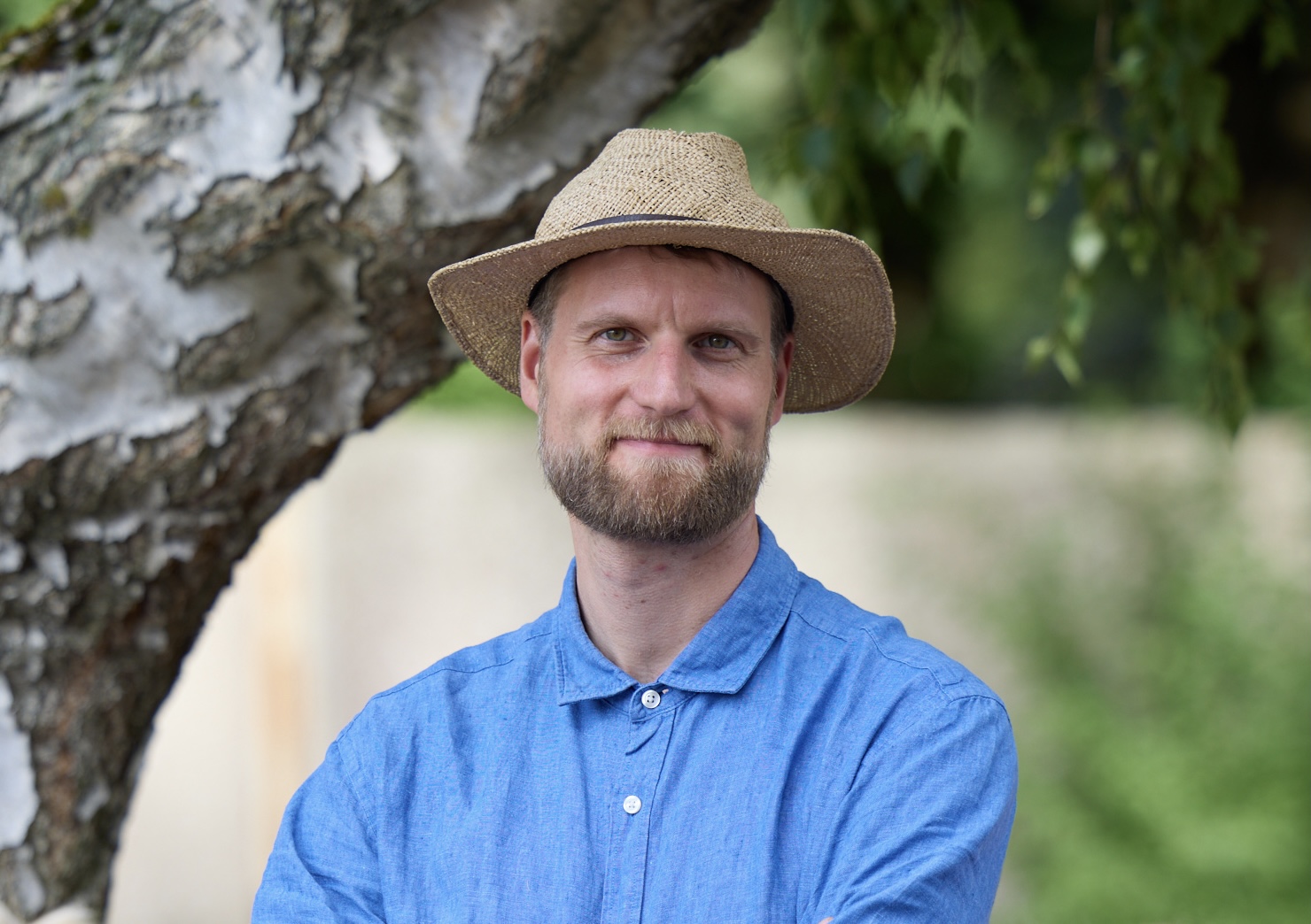 Mann mit Hut steht in der Natur 