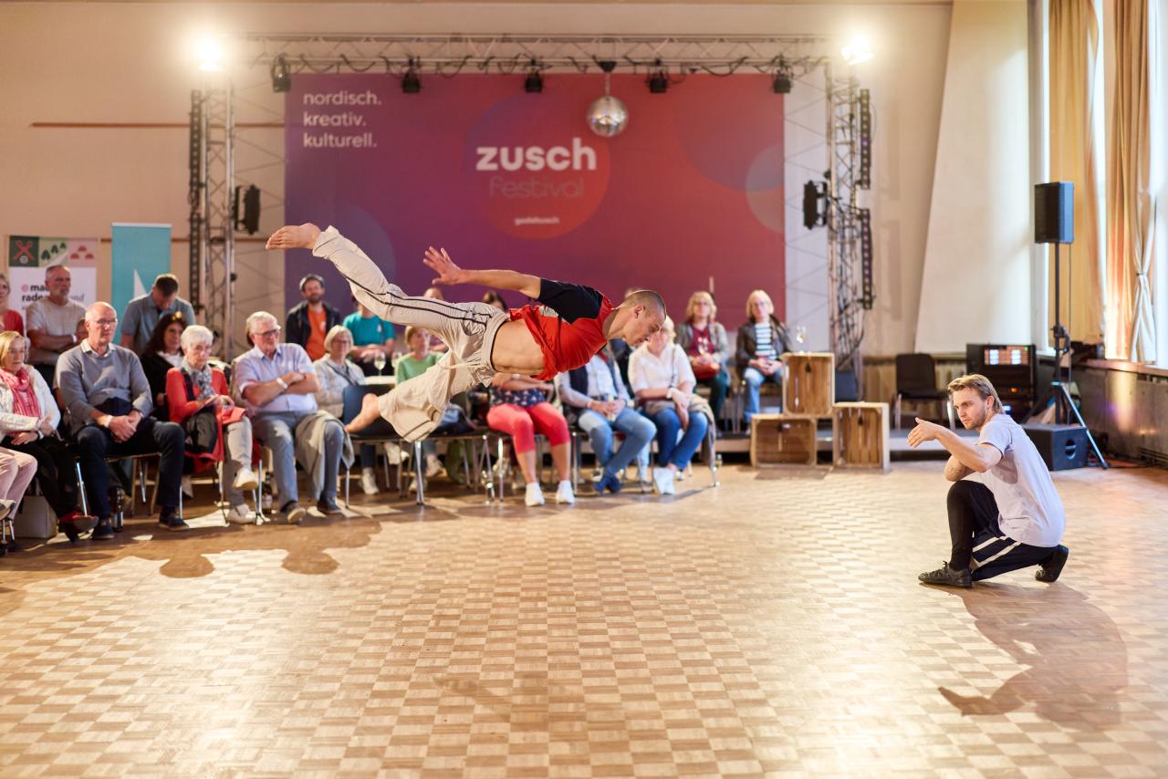 zwei Tänzer führen vor Publikum eine Tanzperformance auf