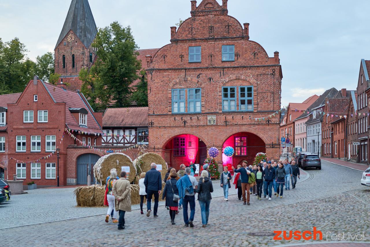 zwei Gruppen von Besucher:innen begegnen sich auf dem Marktplatz von Gadebusch