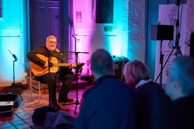 Musiker mit Gitarre sitz im Rathau-Foyer