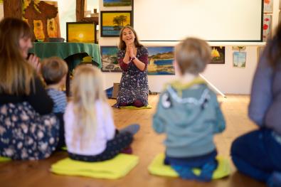 eine Frau singt und klatsch für kleine Kinder ein Lied