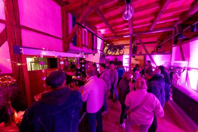 Menschen stehen an der Bar im pink beleuchteten Museum