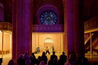 eine Tänzerin und Musiker gestalten eine Performance in der Kirche