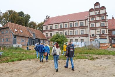 Menschen laufen auf Remise (Gebäude) zu